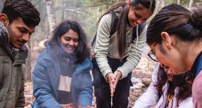 students warming up by fire - Recreation and Leisure Services - Fast Track